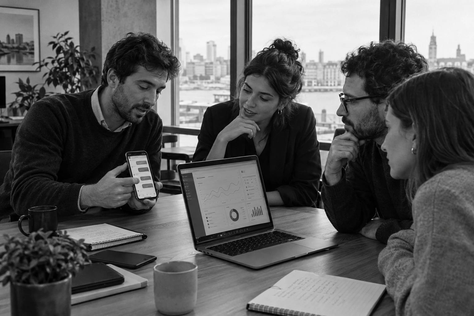 Dos equipos revisando juntos un chat de WhatsApp en un celular y un panel de clientes en una laptop